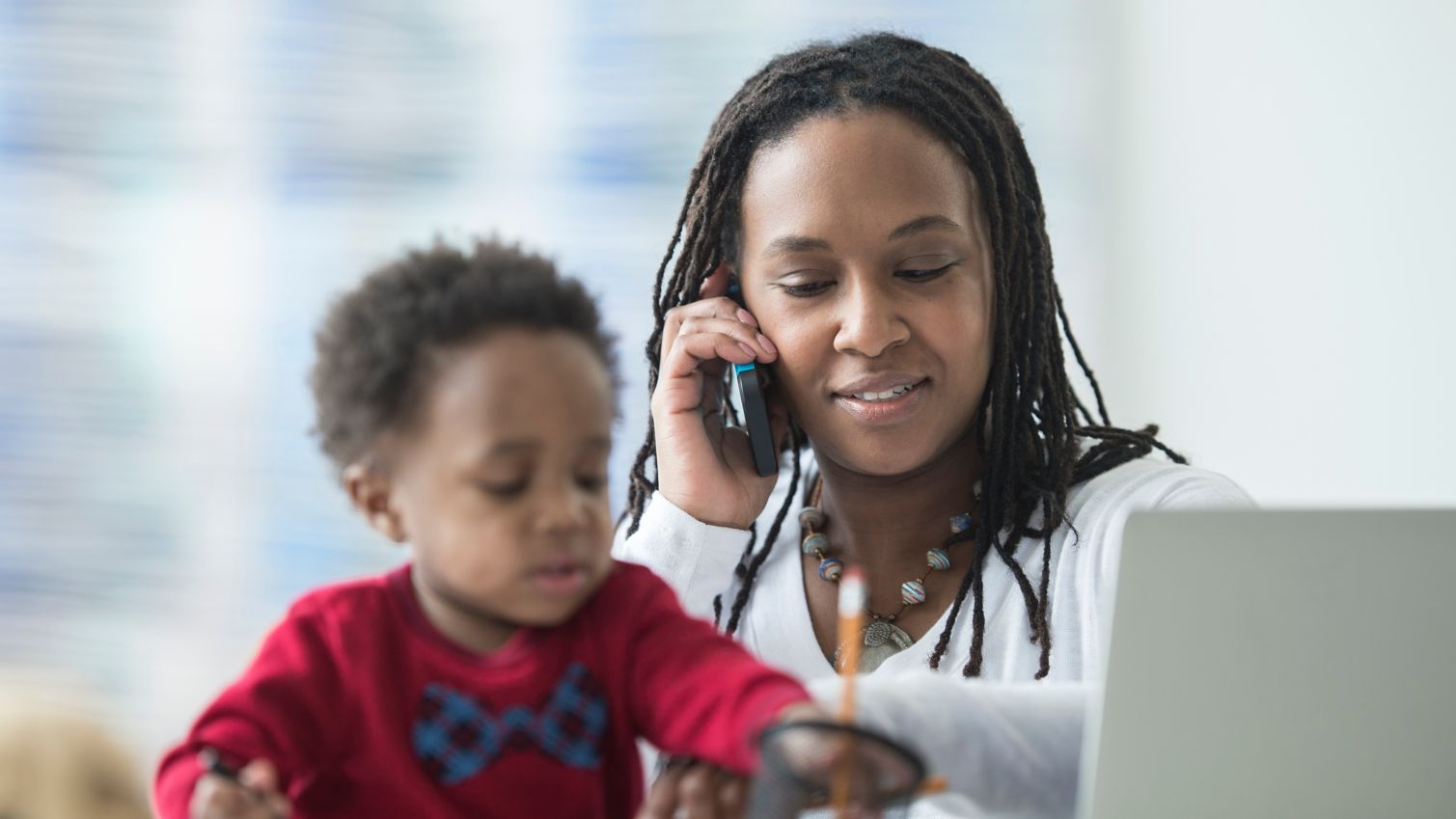 Mom talks on phone while sitting next to son